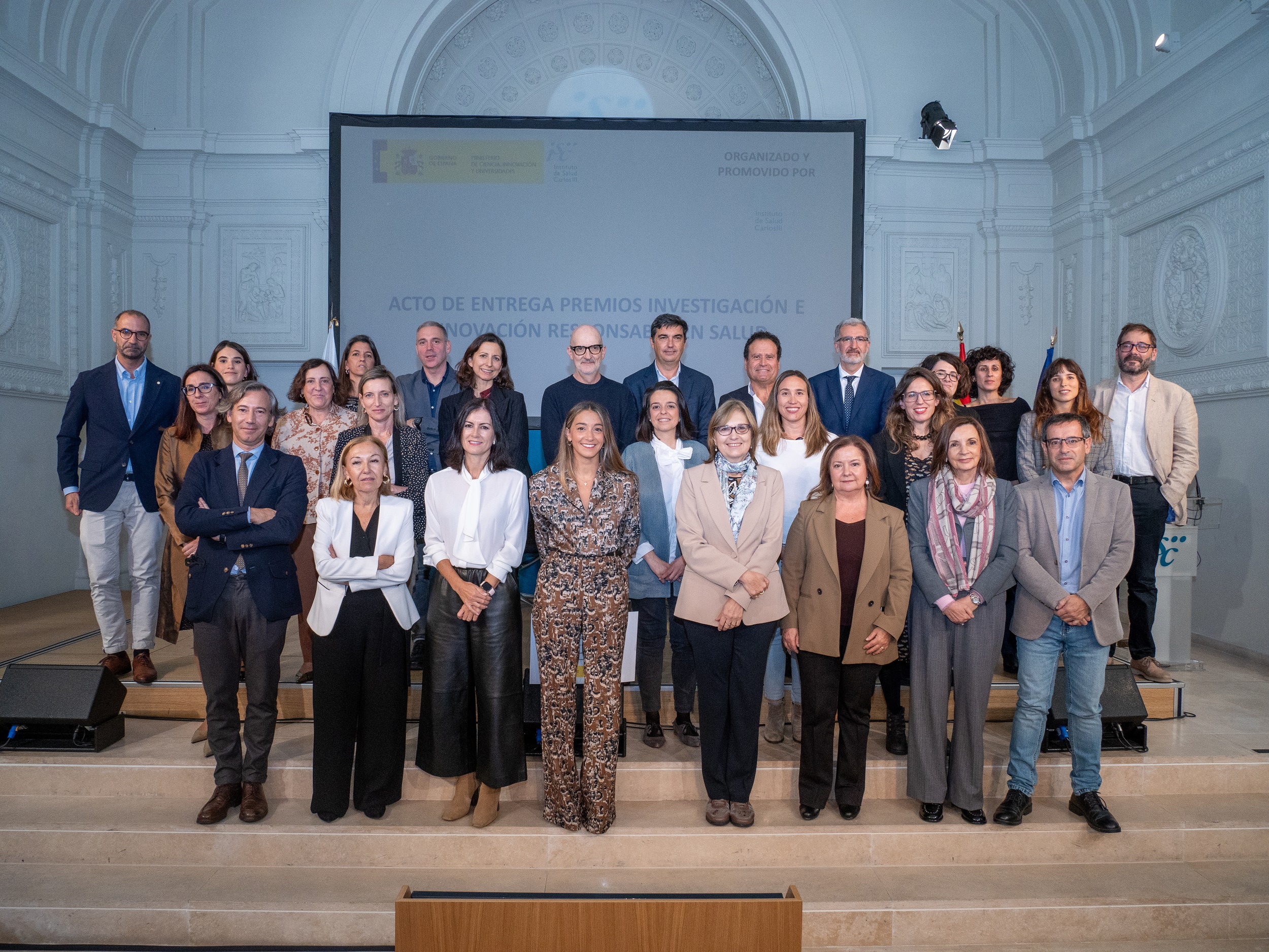 La directora del ISCIII, Martina Pollán, y la subdirectora Pilar Gayoso (5º y 6º por la izquierda, en la fila de abajo) posan con los premiados y premiadas en las convocatorias 2020, 2022 y 2024 de los Premios ISCIII de RRI en Salud.